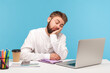 © khosrork - Bored sleepy man office worker napping sitting at workplace with laptop on desk leaning head on hand, feeling boredom, lazy to work, overworking. Indoor studio shot isolated on blue background