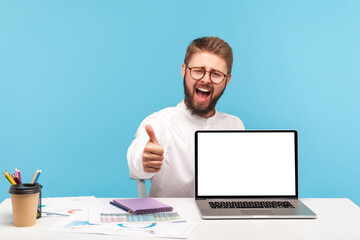 Wall Mural - extremely happy satisfied man office manager showing thumbs up sitting at workplace with empty scree