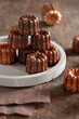 © Noemi Hauser/Stocksy - Canelé - French pastry on a grey plate