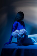 © Katarina Iliskovic/Stocksy - Female model in a blue bodysuite with a vase of flowers