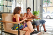 © Ivan Gener/Stocksy - Diverse friends talking on a hostel lobby