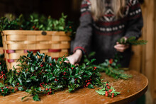 Florist Making Holiday Wreath With Holly