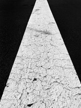 Cracked White Line On Asphalt Road