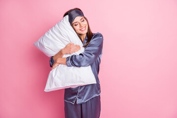Photo portrait of gorgeous girl hugging pillow with closed eyes isolated on pastel pink colored background