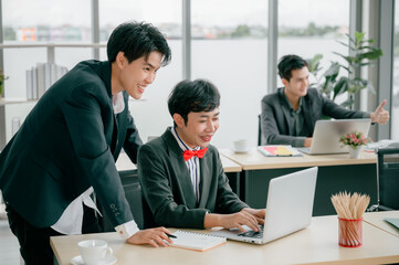 Wall Mural - Group of young business people sit at their desks with smiling colleagues together in the office.  Meeting business people  planning concept, laptop meeting ideas. Concentrate on work. LGBT teamwork.