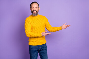 Poster - Photo of friendly man hands demonstrate invitation sign wear yellow sweater jeans isolated purple background