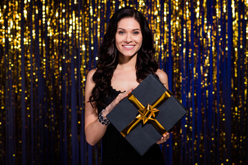 Poster - Portrait of charming person arms hold x-mas giftbox beaming smile look camera isolated on shiny background