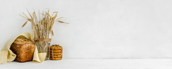 banner with a white wall background and copy space - Homemade grain bread and a linen napkin. Home kitchen cooking decor.