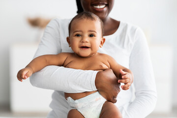 Wall Mural - African American mom hugging her cute infant at home