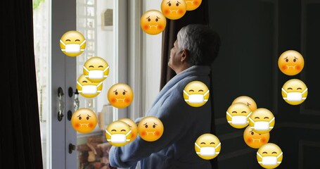 Canvas Print - Animation of emojis wearing face masks over worried senior woman by window