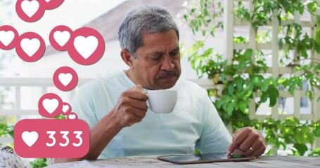 Sticker - Animation of heart love icons over senior man using tablet, drinking coffee at home