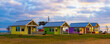 Multicolored cabins on the lakeshore at sunrise with bold skies