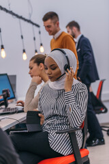 African american muslim girl with hijab and headset working  as customer support in a modern office.