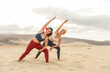 © merla - Two sportive women meditating and doing yoga at the beach