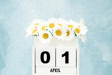 Cube Calendar For April With Daisy Flowers Over Blue With Copy Space