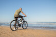 © Adrián - Boy with green shirt and mask arriving at his destination after a bike ride to rest on the beach