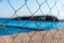 Fence Mesh Fence On The Background Of The Blue Sea And The Sunken Ship