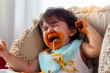 Wayward little toddler child or infant baby crying that don't want eating food on baby chair Cute infant children get hungry and want new food Children get dirty Kid get tantrum Baby is stubborn baby