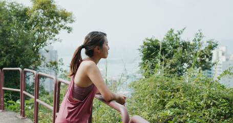 Wall Mural - Sport woman look at the city view from mountain