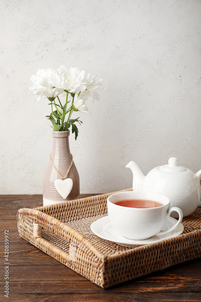 Wicker tray with hot tea on wooden table