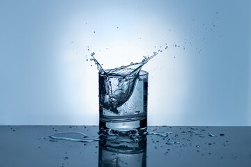 Splash of water in a glass. Splashing water. Ice water. Concept. High quality photo