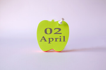 Calendar for April 2 : the name of the month April in English, the numbers 02 on the sheets for writing in the shape of an apple, a pin, a light background