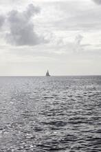Vertical Shot Of A Lone Sailboat On The Sea