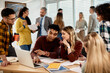 © Drazen - College students cooperating while suing laptop in the classroom.