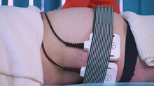 CU: Cosmetologist Puts Tools Under Belt On Plump Client Large Belly With Stretch Marks For Electrical Myostimulation In Cosmetological Clinic Closeup