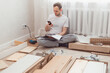 © vladdeep - Man looking contacts of help center. Troubles with assembling new furniture, calling for a master.