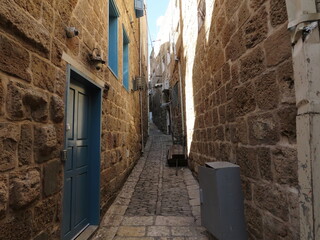 A view of a narrowing street between houses in the old city of Acre, Israel. Ancient walls of architecture and the culture of Muslims.