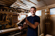© Connect Images - Craftsman holding wood plane in workshop