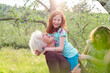 © Connect Images - Girl getting carried by grandmother, with mother in garden