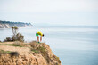 © Connect Images - Runner stretching on cliff top, Santa Barbara, California, USA