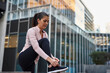 © Connect Images - Woman tying shoelace on sidewalk, Barcelona, Catalonia, Spain
