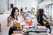 © Connect Images - Young businesswomen browsing book in bookshop