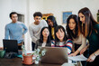 © Connect Images - Group of young businesswomen and men looking at laptop in office meeting