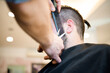 © Connect Images - Hairdresser trimming customer's beard in barber shop