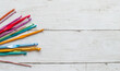 Colorful  crocheting hooks of different sizes on a wooden background with copy space
