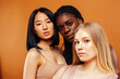 © iordani - young pretty asian, caucasian, afro woman posing cheerful together on brown background, lifestyle diverse nationality people concept