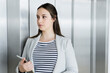 © Connect Images - Businesswoman with digital tablet leaning against elevator door