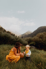 Mother Looking At Wildflower With Toddler Daughter In Rural Valley, Mineral King, California, USA