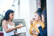 © Connect Images - Young woman with teenage sisters while eating cakes in doorway