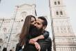 © Connect Images - Couple playing piggyback ride and kissing, Santa Maria del Fiore, Firenze, Toscana, Italy