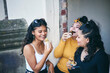 © Connect Images - Young woman with teenage sisters eating cakes in doorway