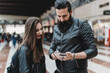 © Connect Images - Couple using smartphone in station