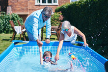 Grandparents Supporting Granddaughter In Pool