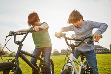 Two Boys Riding Their BMX Bikes In A Park.