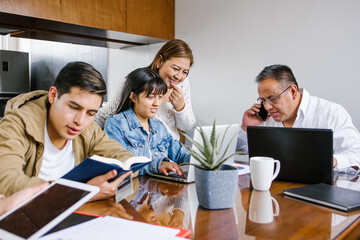 Wall Mural - Mexican Family at home as the pandemic coronavirus (COVID-19) forces many employees and students to work and study from home in Latin America