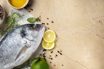 Wall Mural - Delicious and healthy food. Fresh borabo fish with grill pan and ingredients for cooking on marble background top view